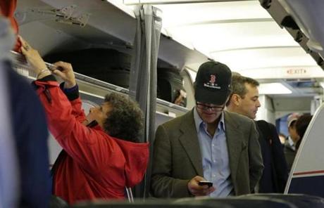 A man wore a Red Sox World Series hat as he boarded a plane in Boston.
